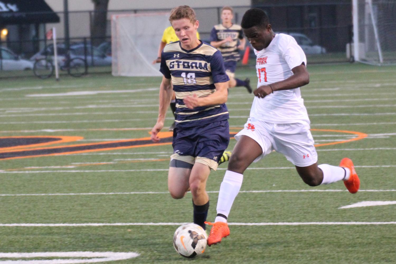 Sophomore Randy Mayele fights for the ball with a Chanhassen player. Boys Varsity tied in overtime on September 14.