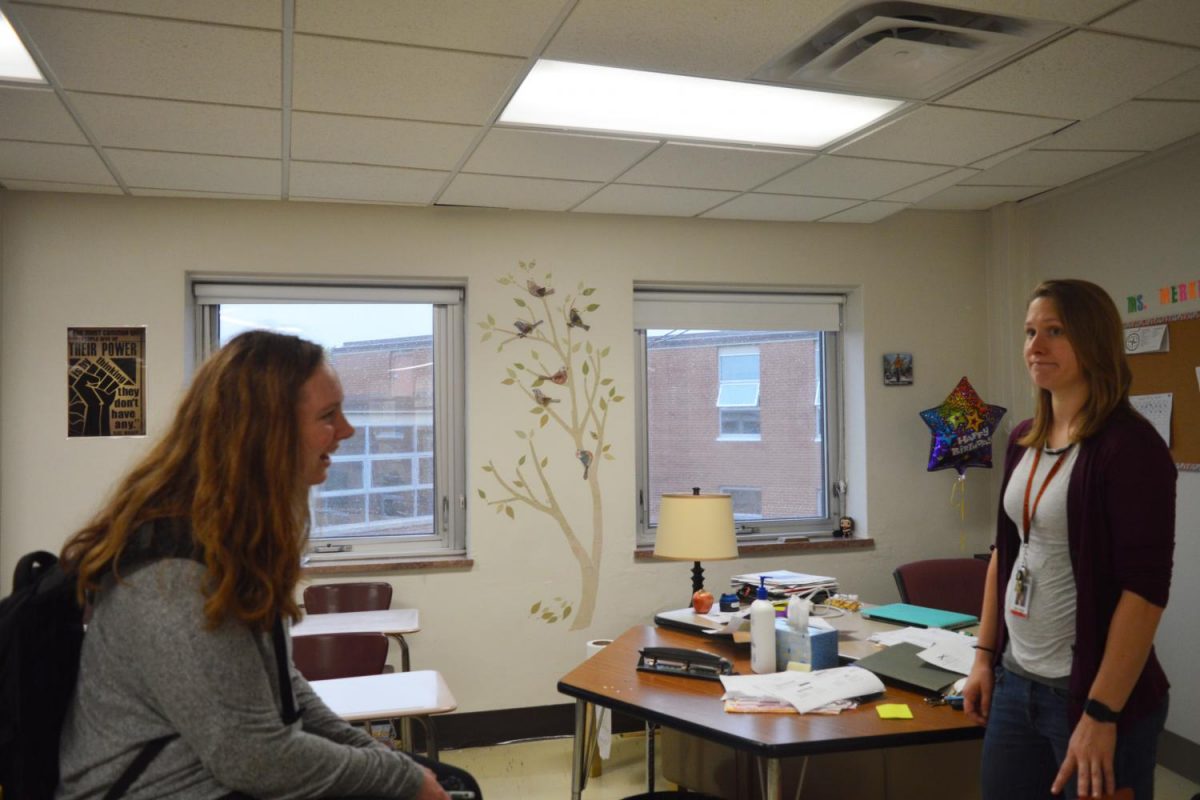 Junior Cailey Hanson-Mahoney talks to social studies teacher Jillian Merkle about the possibility of Merkle being the adviser for the Science Olympiad. Former members of the Science Oympiad team have been having challenges finding an adviser and forming the club again this year.
