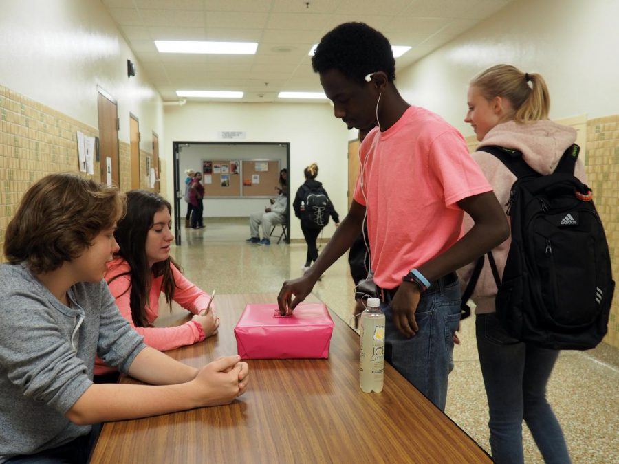 Sophmores Ian Otos and Shayla Miller collect breast cancer donation from sophmore Nebyu Bekele.
