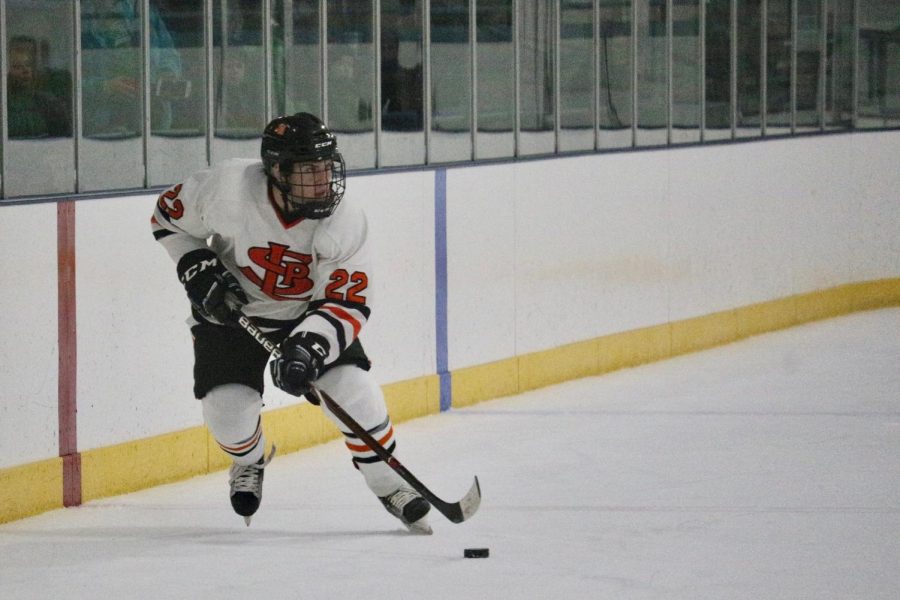 Senior Forward Willy Basill carries the puck down the ice, looking for teammates to pass to. Park scored their first two goals early in the first period in their 8-3 loss against Edina.