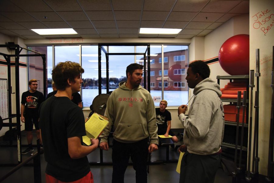 Football Coach Ben Wolfe aids players during their off-season Dec. 11 in the weight room. Wolfe received the 2017 All-Metro Coach of the Year award by KARE-11. 