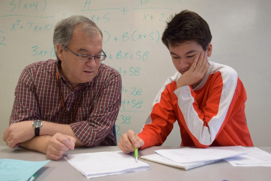Dan Walker assists Junior Oliver Swenson with his math work.