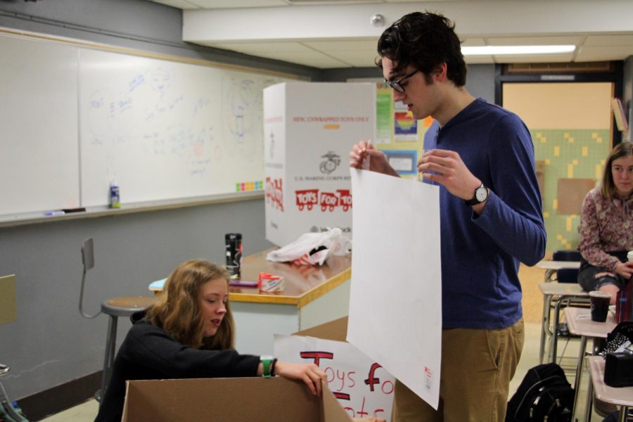 Quill and Scroll senior president Caroline Green and service project coordinator Atticus Raasch prepare the Toys for Tots donation boxes during the Quill and Scroll meeting Dec. 4. They are organizing a Toys for Tots fundraiser that ends Dec. 11.