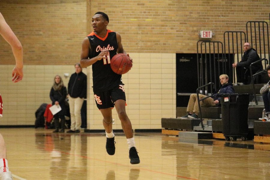Senior Cire Mayfield dribbles down the court in the Orioles win over Benilde Jan. 30. Mayfield is ten points away from his 1000th career point. Mayfield will look to make history as the Orioles play 7 p.m. Feb. 9 at the high school against Chaska.
