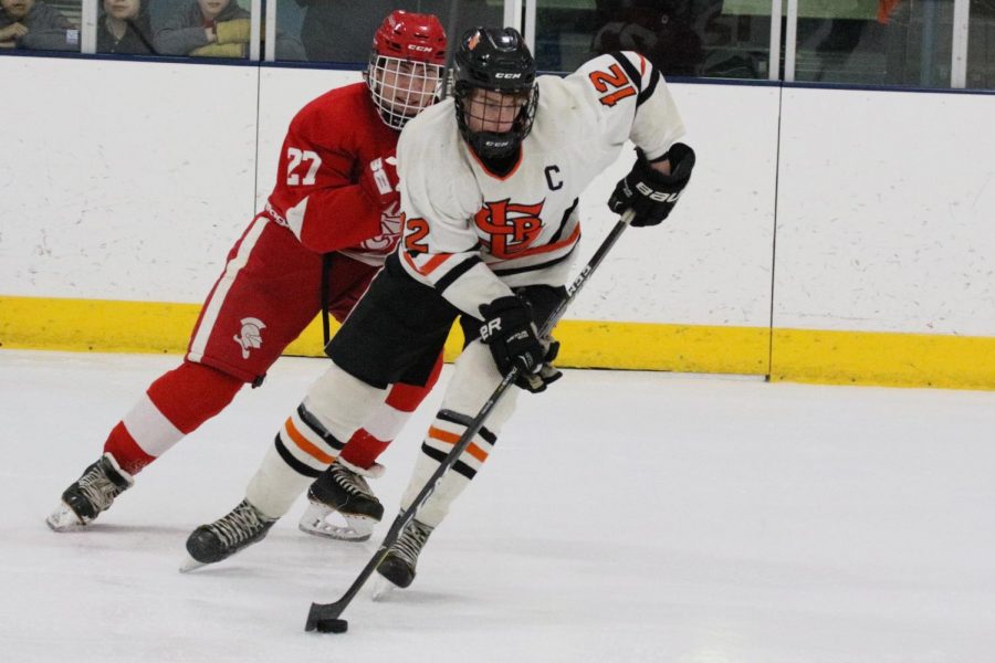 Senior captain Shae Pekarek carries the puck down the ice in Parks 4-0 loss to Benilde Feb. 13. Park went scoreless with a goal being called off in the second period.