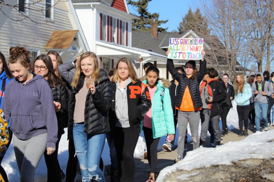 Park students hold signs as they march to the fire station on Wooddale Avenue. Students walked out of class at 10 a.m. to support the national walkout. 