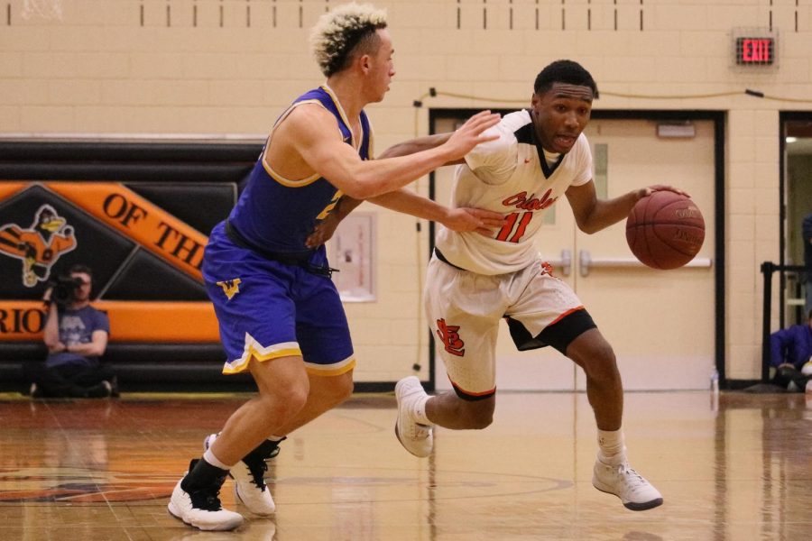 Senior+Cire+Mayfield+drives+to+the+basket+against+Wayzata+defender+Kody+Williams.+The+Orioles+were+defeated+by+the+Trojans+66-59+Mar.+9.