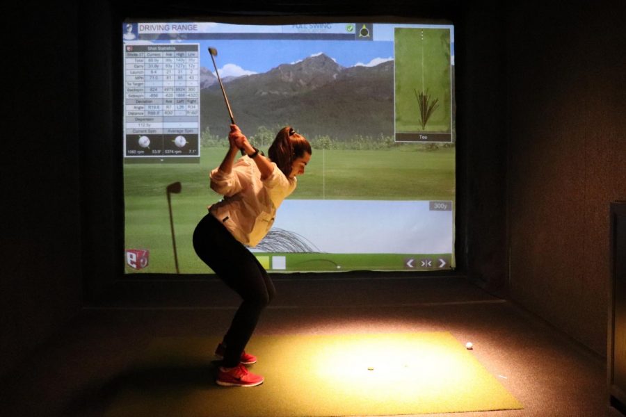 Junior Rachel Salzer practices her swing at golf practice April 12. The team has been practicing indoors at the St. Louis Park Lifetime Fitness due to cold weather. 