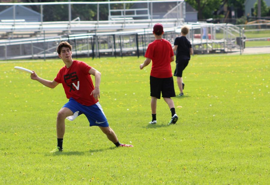 Sophomore Daniel Eyal steps to the side and delivers a forehand pass during the ultimate teams practice May 23.