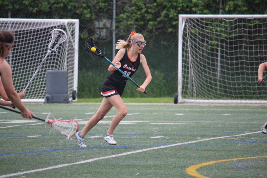 Freshman Anna Jensen sprints towards the net. The Orioles will play their second Sections game June 1.