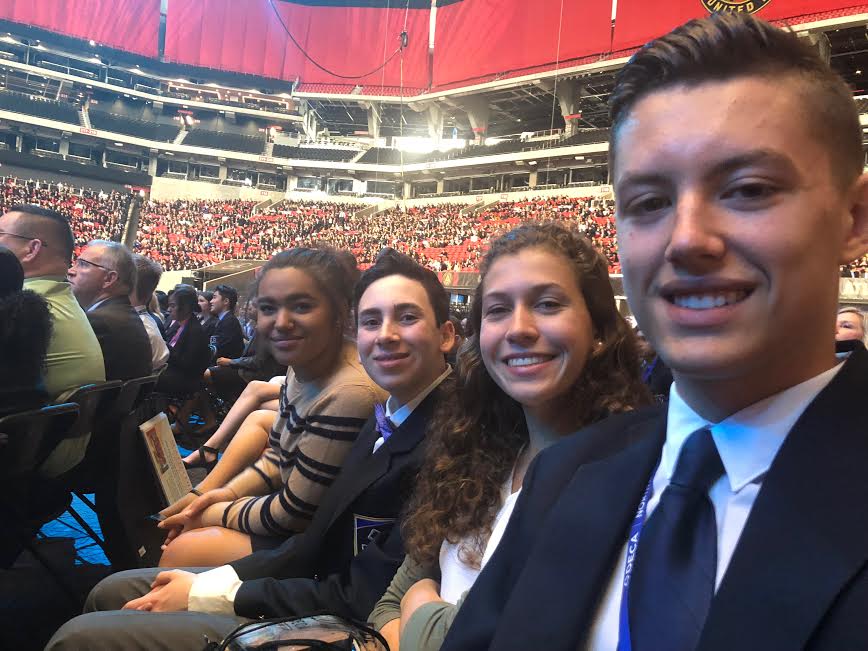 DECA members Senior Louis Brown and Juniors Rachel Young, Yonah Davis and Alexis Machoka take a selfie at a conference during DECA nationals.