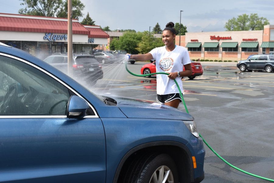 Senior Gabby McCaa washes cars at the volleyball fundraiser. 
