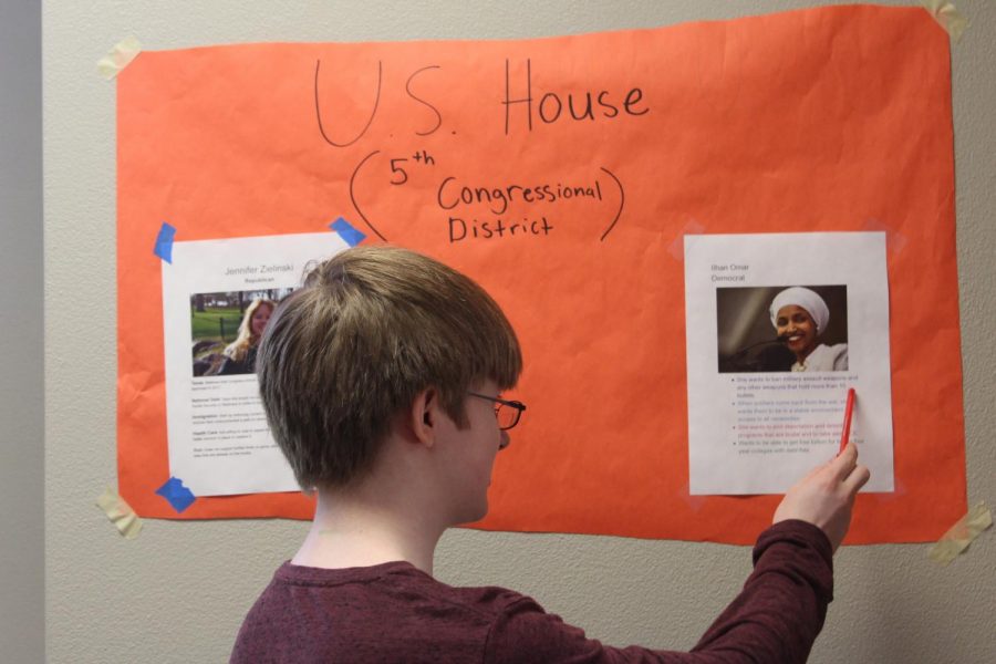 Sophomore Joseph McIndoo learns about NTA club poster encouraging students to vote. Several more Posters are hung up around the high school cafeteria. 