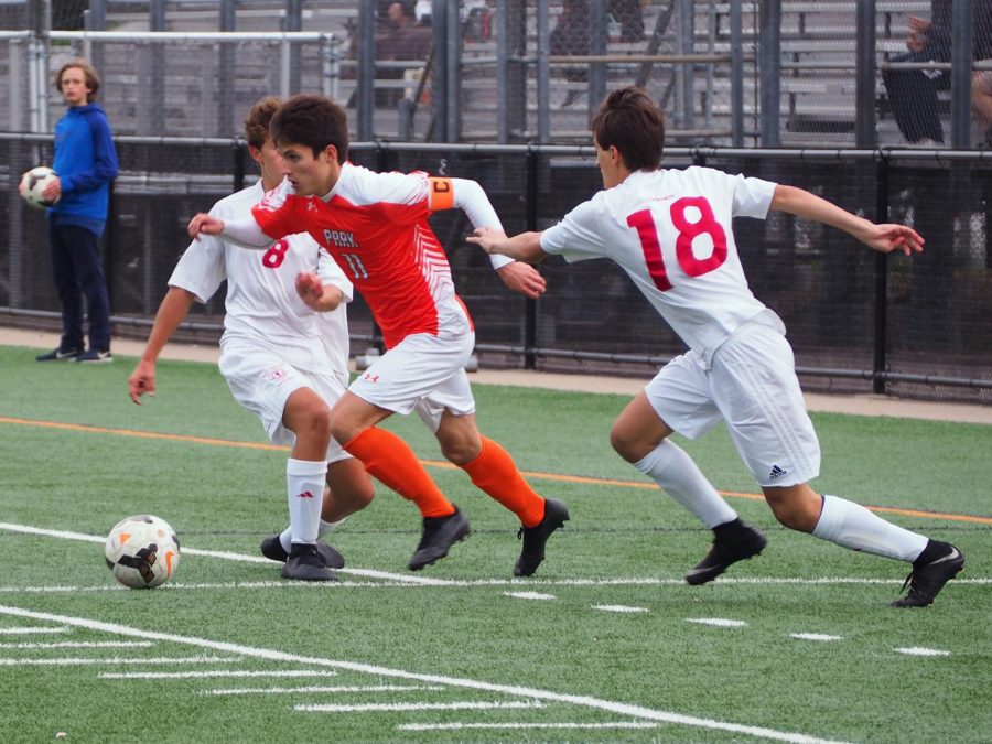 Junior Nicholas Riley attacks the space and slips past two Benilde defenders. Park boys will have to use smart dribbling skills when they face the top team in the state Washburn, Oct. 6th.