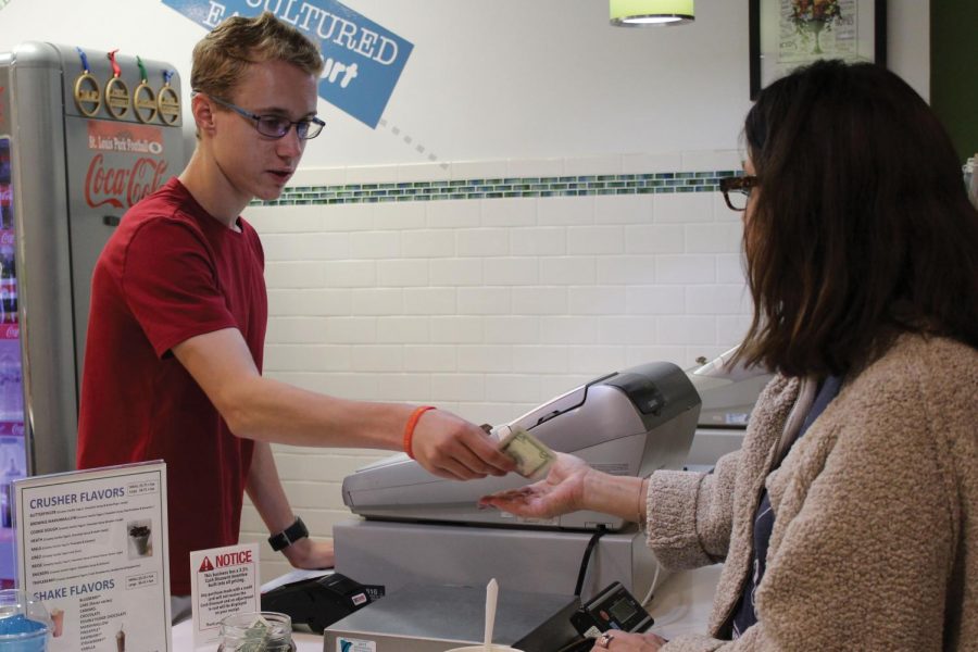 Sophomore Jackson Thoe gives change to a customer at Park Yogurt. The store was in business for four years before its closing. 