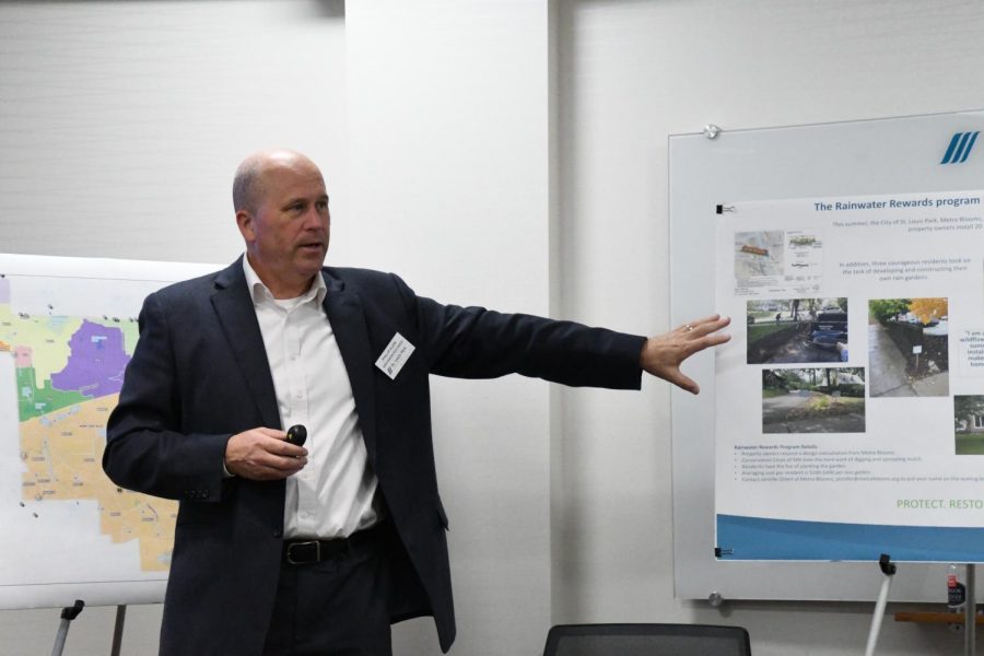 Senior engineering project manager Phillip Elkin talks to community members at the Water Plan meeting. Elkin referenced the poster with information about rain gardens and their effect on the St. Louis Park community as a whole.   