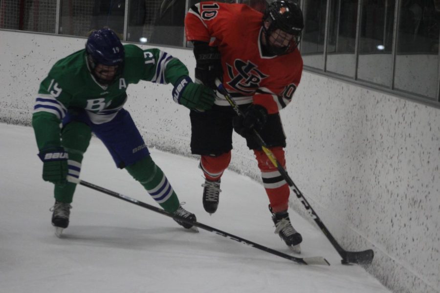 Sophomore Sam Berry steals puck away from Blake player junior Will Svenddal.
