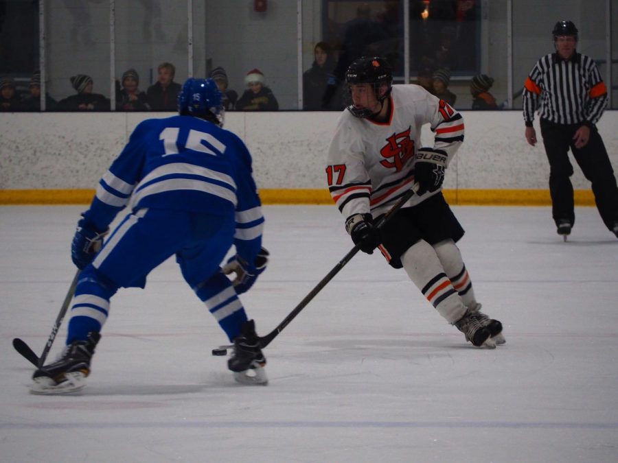 Sophomore Drew Boyum looks for an open player to pass to as sophomore Duke Kiffin attempts to take the puck. Minnetonka beat Park 8-1 December 6. 
