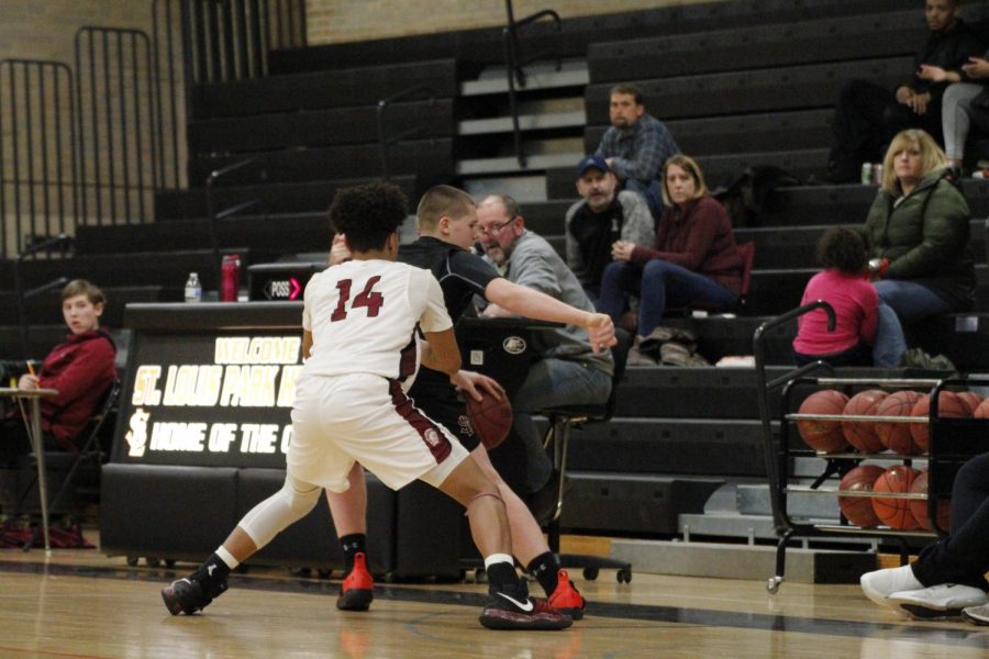 Junior Cole Ewald turns his back to Richfield player to prevent him from stealing the basketball.