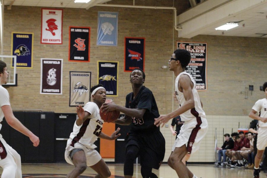 Sophomore Paris Johnson slips between two of Richfields defenders with the basketball in his hands. Park beat Richfield 97-79 on January 17. Their next game is against Benilde-St. Margarets at 7 p.m. Jan. 22 at Benilde-St. Margarets School.