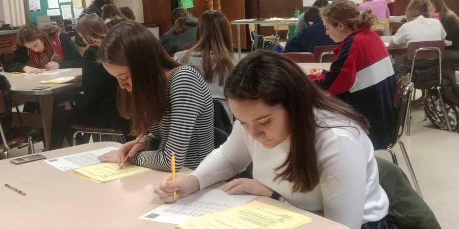 Senior Krista Morhauser and junior Hannah Odland take the DECA exam Jan. 8. The 100-question test will contribute to their score at the DECA district competitions Jan. 28.
