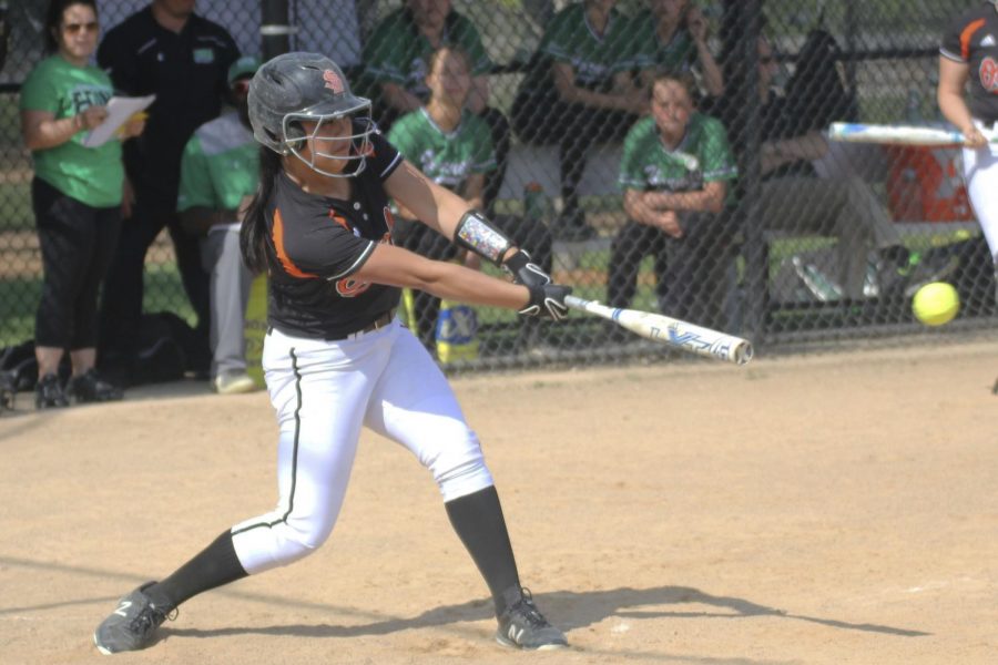 Senior Sophie Olmen swings a bat at a varsity softball game in the 2018 season. Olmen was recently awarded the Athena Award for her performances in tennis, basketball and softball. Olmen has played softball since freshman year but took a year off to participate in golf. 