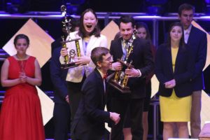 Sophmores Daniel Goldenberg and Emma Amon step up to receive their third place trophy for their team decision-making event at the 2019 DECA State competition.