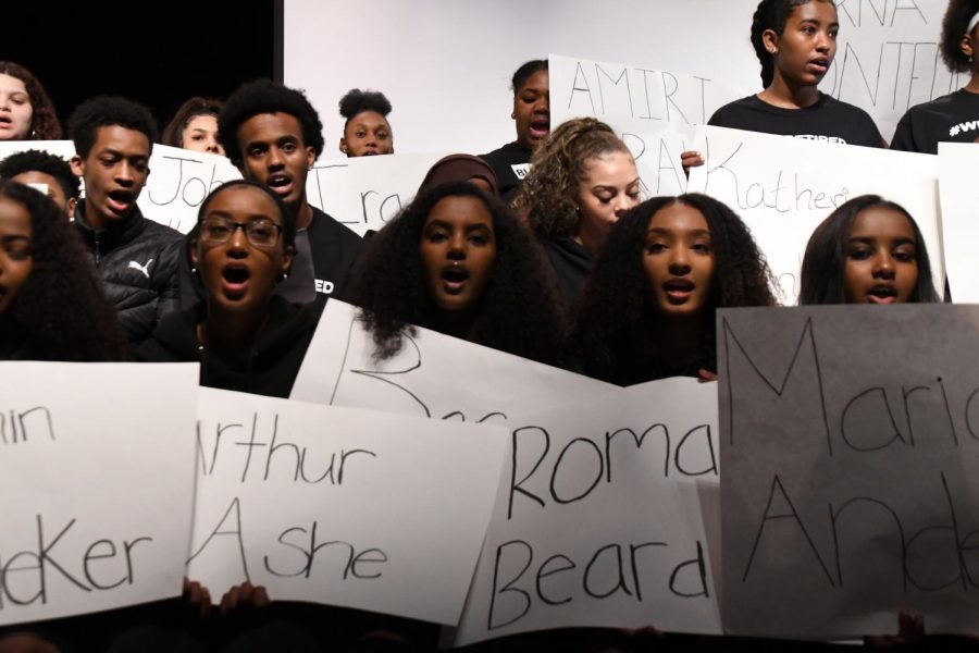 At the beginning of the Black History Month presentation students sat on the stage holding signs with the names of famous and acclaimed people of color. Students announced that they are tired of the treatment of black people and how little it has changed. 