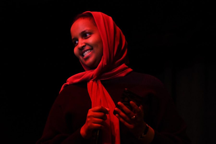 Senior Muna Ahmed smiles while the crowd applauds her after reading a poem during the multicultural show, April 12. During the show, students performed in a variety of different mediums such as song, rap, dance and spoken word.