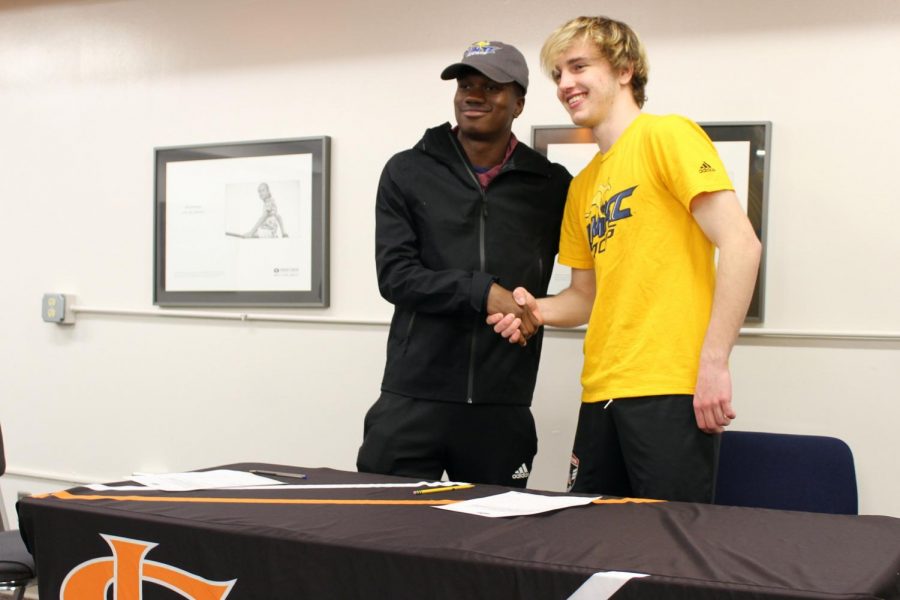 Seniors Emmanuel Iwe and Zinedine Kroeten shake hands after signing to play soccer for University of Missouri Kansas City, April 21. They began playing together at the soccer club Joy of the People.