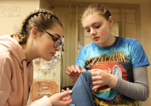 Junior Morgan Graves helps sophomore Ainsley Preston Pepperell sew a costume for The Amish Project. Graves exercises her sewing skills by helping create costumes for the school productions, as well as teaching others how to successfully create costumes through sewing.