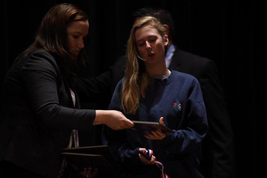 Assistant Principle Jessica Busse hands senior Natalie Aune her academic award during the academic awards ceremony. 