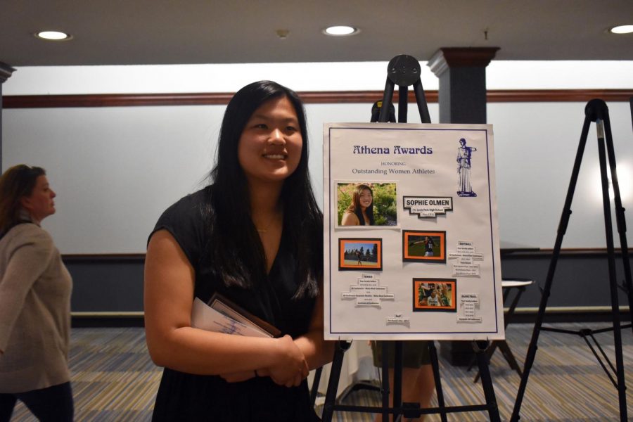 Senior Athena award recipient Sophie Olmen poses for a picture by her poster board that contains information on her athletic acheivemnets during her high school career.