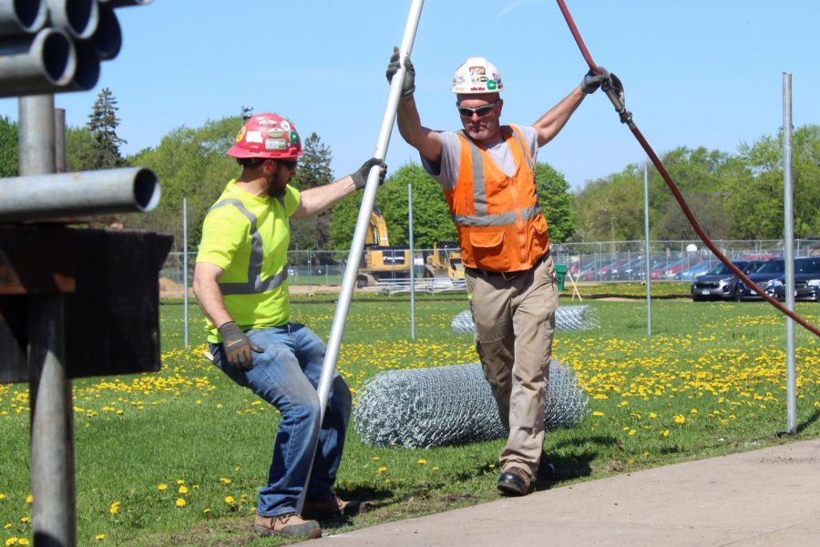 Construction workers install a pole that will be part of the fence surrounding the construction of the new fitness center. According to facilities manager Tom Bravo, the center should be completed by January 2020. Other renovations on the school will begin in fall 2019. 