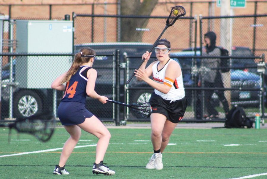 Junior Sarah McCallon looks to pass the ball to her teammate April 26. The team won 15-2. McCallon is one of the current captains for the girls lacrosse team.