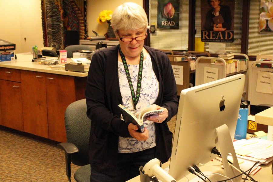 Librarian Ellen George goes through a book making sure everything is in good condition. You can find Ms. George in the Media Center at the front desk.