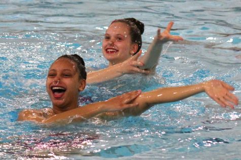 Sophomore Bella Steward and junior Isabel Kjaer smile while swimming their Brittany Spears duet at free rehearsal May 14. Steward and Kjaer placed second in the extended division for duets at Sections which took place May 18.