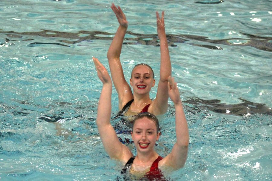 Juniors Ava Tronson and Annie Breyak smile as they perform their team routine at Sections. The routine placed first in the extended team division at Sections, May 18.