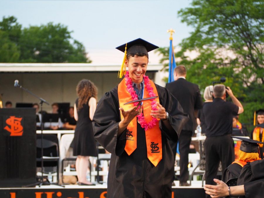 Graduate Ethan Hoeschen spins his diploma on his finger as he walks off the stage. Seniors had an overnight party at Bowlero after graduating. 