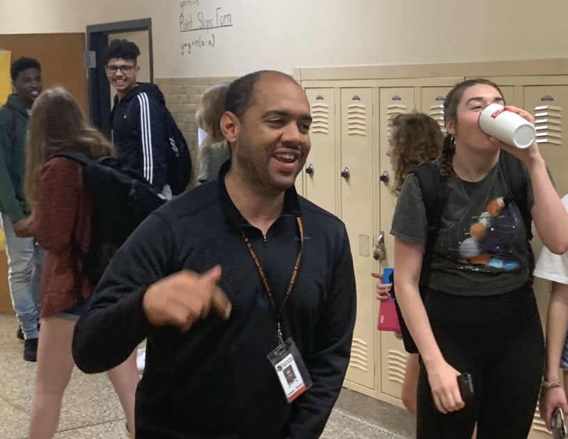 Math teacher Anson Opara dances to music blasting through the hallway during passing time. The math teachers play the music to remind students to be on time to their next classes. 