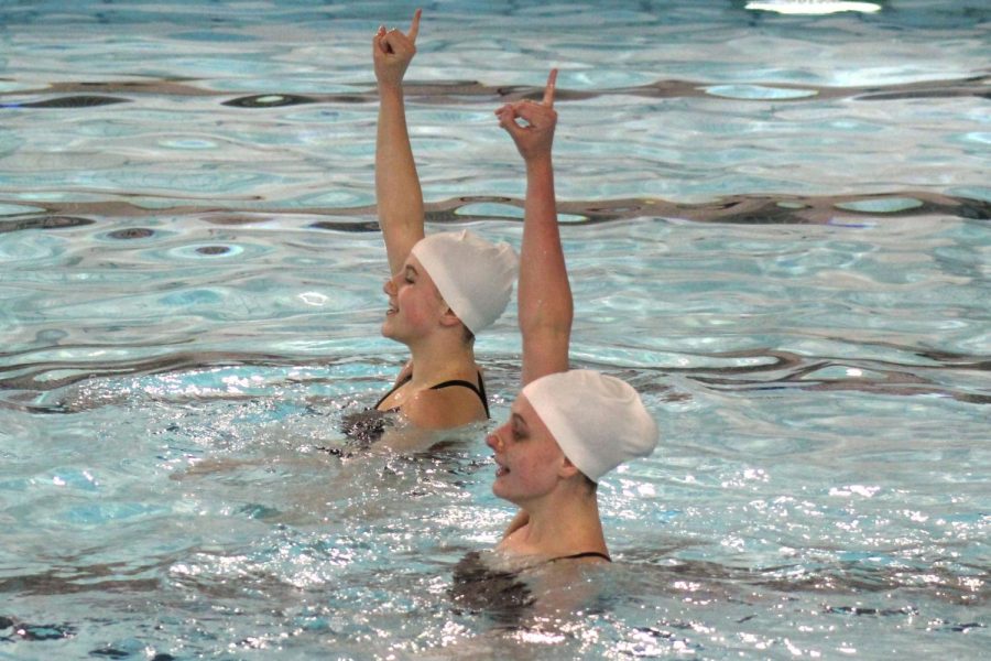 Juniors Annie Breyak and Ella Hammerstrand hold up their pinky fingers during the song 24K Magic in their Bruno Mars duet during a routine meet against Bloomington, May 3.