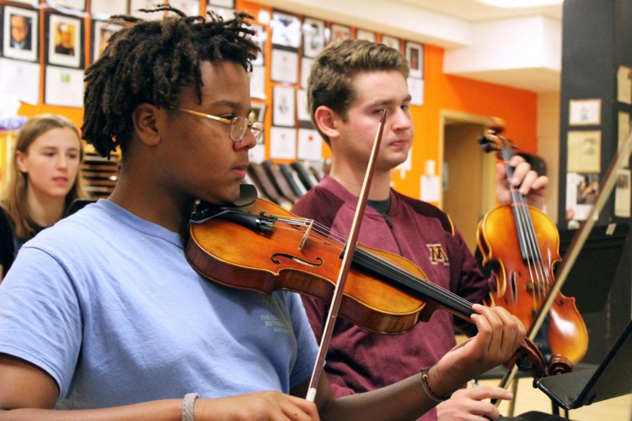 Freshman Meshach Mandel pulls his bow across the strings on his violin during third hour Sept. 20. Orchestra is working toward its Halloween concert Oct. 30.