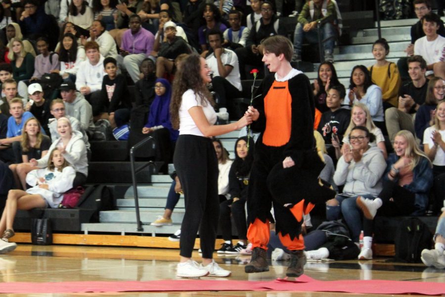 Junior Lilly Strathman gives senior Sam Sietsema a rose after being nominated for Homecoming king. Sietsema dressed up as the oriole mascot for the Homecoming Pep fest.
