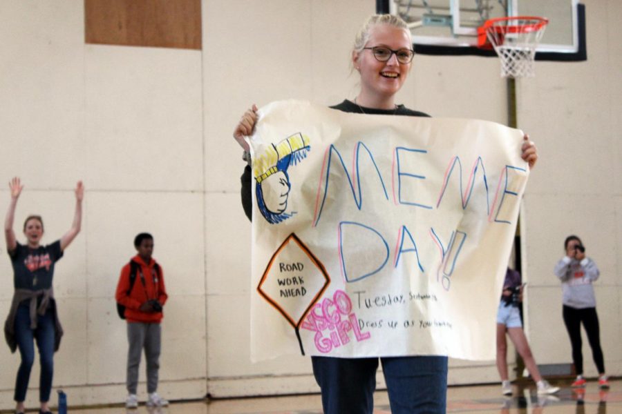 Sophomore Katrina Nevinski walks around with a sign to announce meme day dress code for Sept. 17. Student Council planned a school wide dress code for every day in the week leading up to Homecoming.