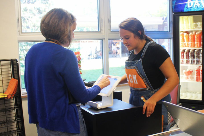 Senior Sarah McCallon helps to checkout a teacher at the Storiole Sept. 20. The Storiole received new merchandise at the start of the school year.