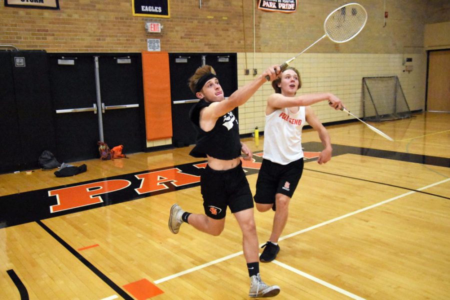 Seniors Jacob Brown and Ian Otos run forward to hit the shuttlecock during the badminton tournament. Badminton was a part of the Homecoming week festivities. 