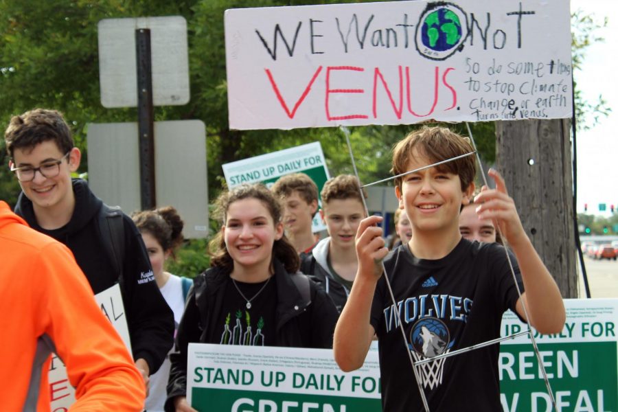 Seventh grader Jason Kraft and junior Dahlia Krebs walk in the climate march. At City Hall participants expressed their feelings on climate change.