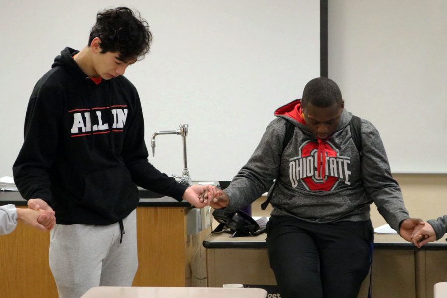 Senior Alex Hager and junior Michael Boxley hold hands in prayer Oct. 15 at FCA. FCA meets Tuesdays 8 a.m. in room A304.