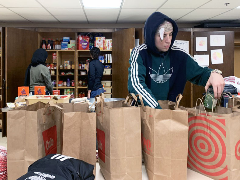 Senior Hayden Haase packs food for Thanksgiving meals Nov. 26. Junior Ayan Hassan helped organize the event in an effort to give families food for Thanksgiving.