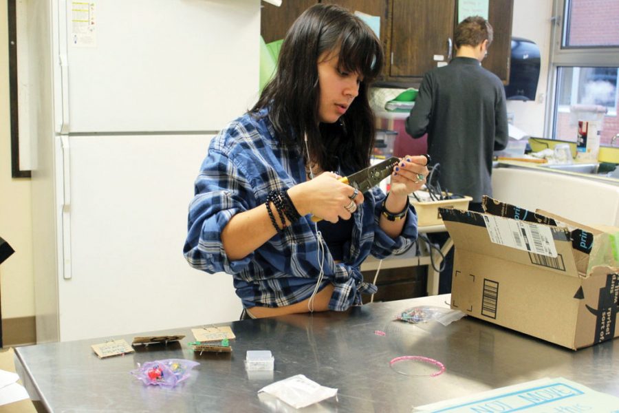 Sophomore Anna Overall makes earrings for her groups small business on Nov. 25. Overalls group Jewelry Junkies makes jewelry from recycled materials and sells their products in school.